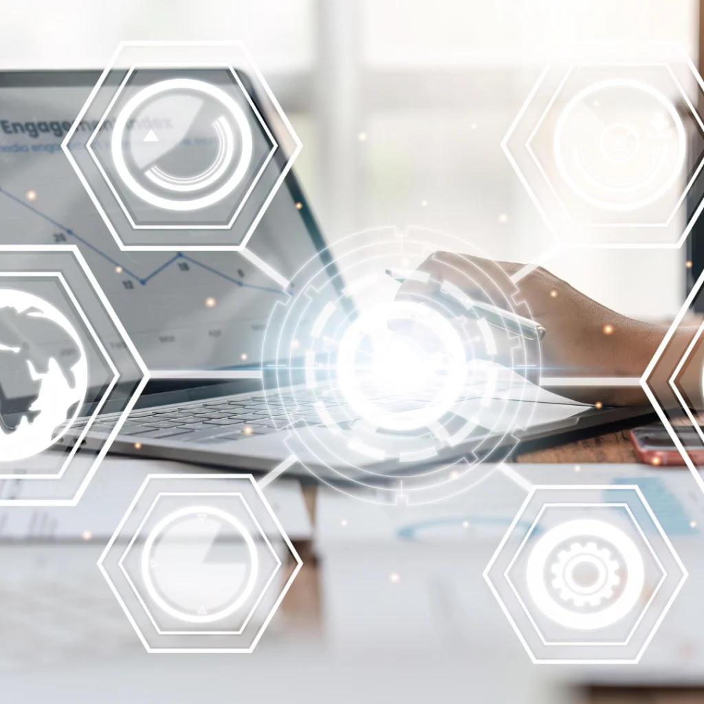 Persona trabajando en un portátil con gráficos digitales flotantes, representando la integración de diversos canales como tendencia clave en el marketing digital. 